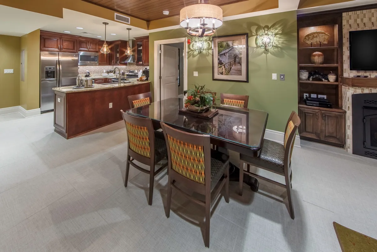 A stylish dining area features a central dining table adjacent to a kitchen island, complemented by tasteful wall art and modern lighting. The setup is perfect for family meals, laughter, and socializing, with a layout that encourages conversation and togetherness.